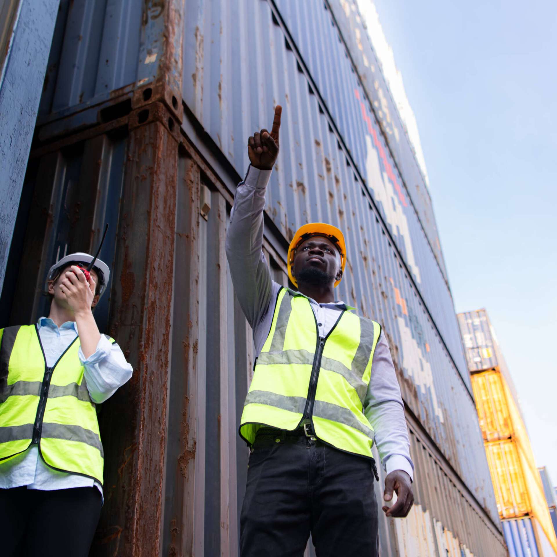 Both of engineers working in the container yard. This is a freight transportation and distribution warehouse.